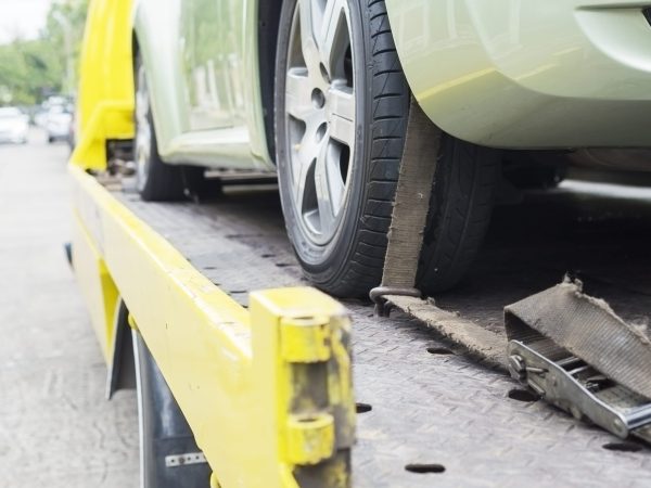 car transporter breakdown lorry during working using locked belt transport other green car for repairing at car center in a bangkok city thailand